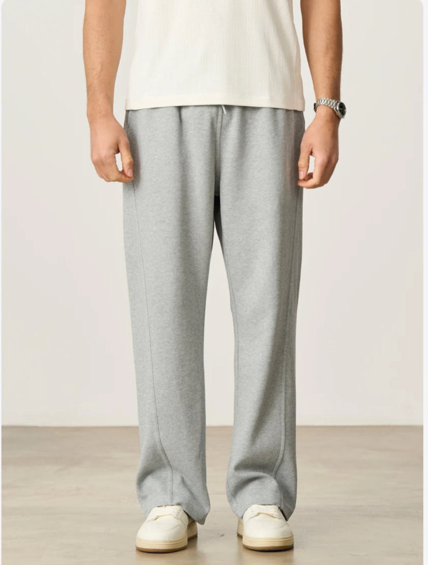 CIIVET - Model wearing grey sweatpants and a white shirt on a plain background