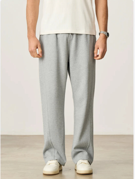 CIIVET - Model wearing grey sweatpants and a white shirt on a plain background